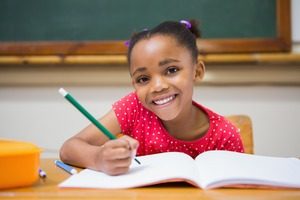 Young girl at school writing in a notebook